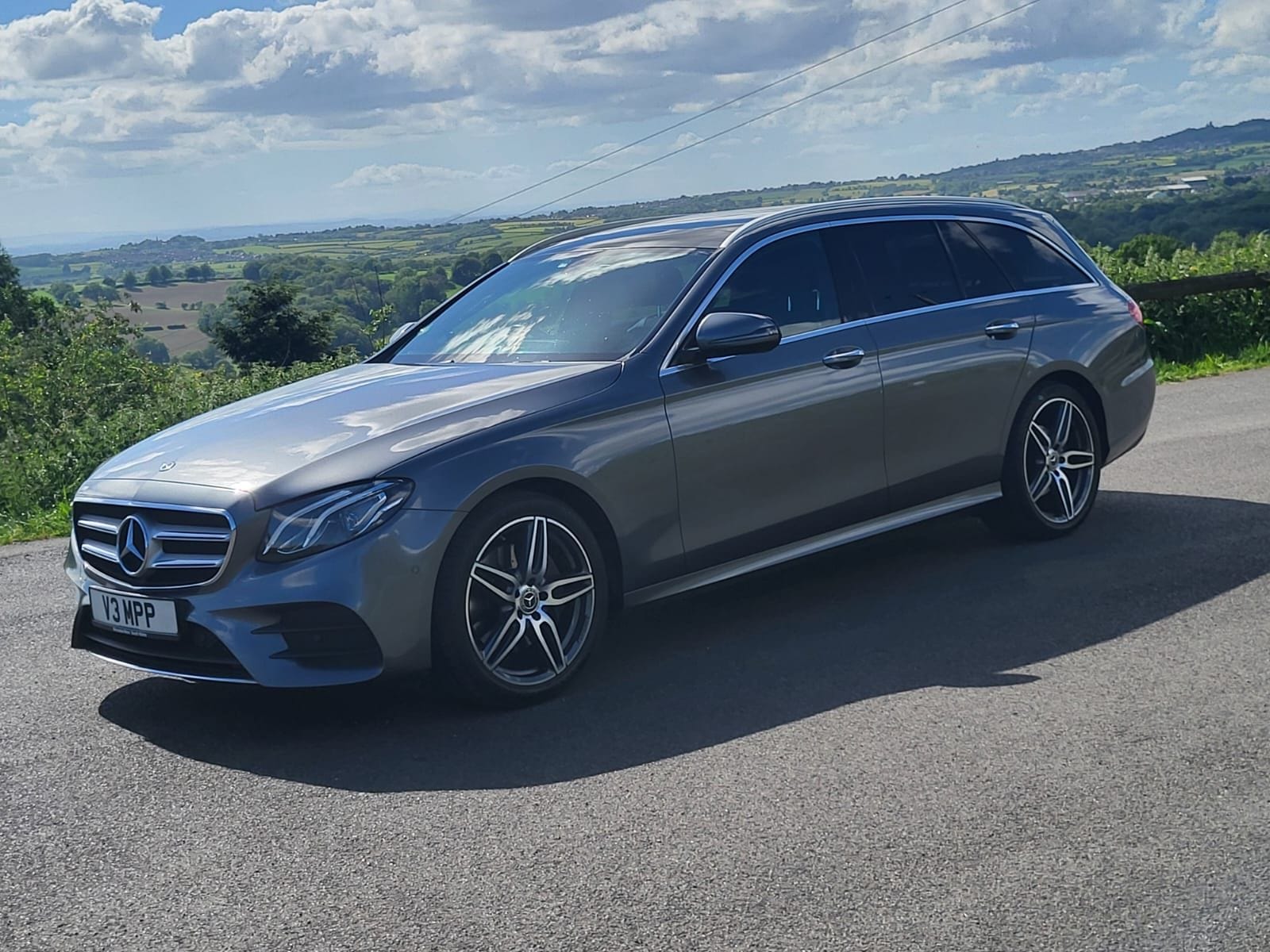 The Top Marks Airport Services Mercedes-Benz E-Class Estate parked above a Staffordshire valley