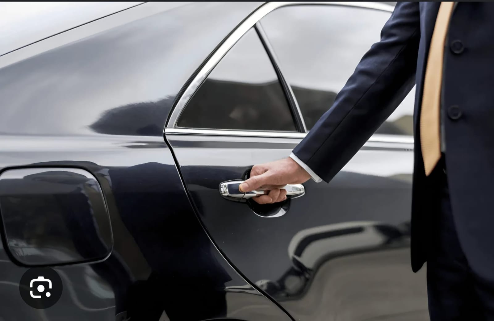 Chauffeur opening the rear door of an executive vehicle